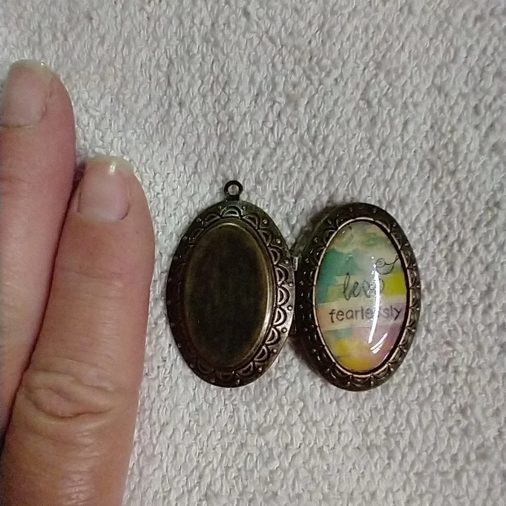 Bronze tone leap fearlessly bird locket pendant
